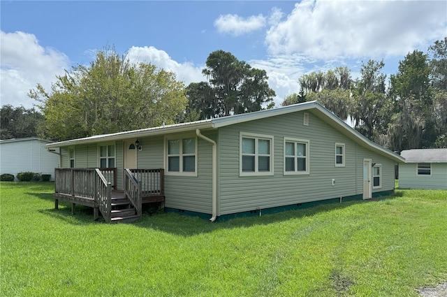 back of house with crawl space and a lawn