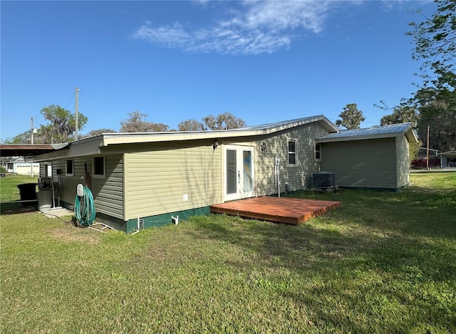 rear view of property with a wooden deck, central AC unit, french doors, and a yard