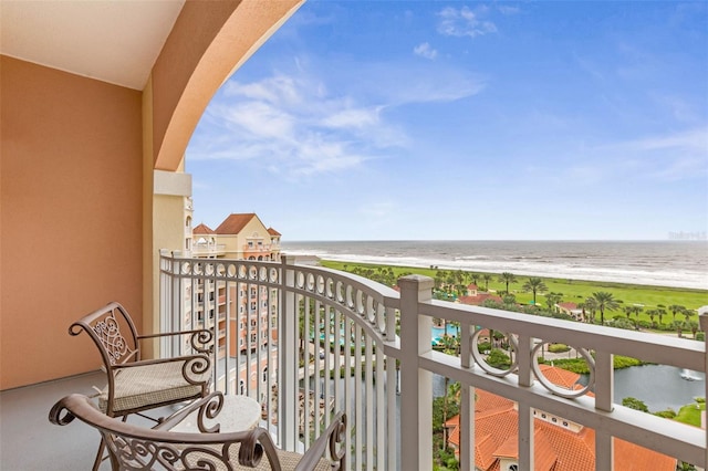 balcony featuring a water view and a beach view