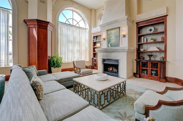 tiled living room with a large fireplace, plenty of natural light, and built in shelves