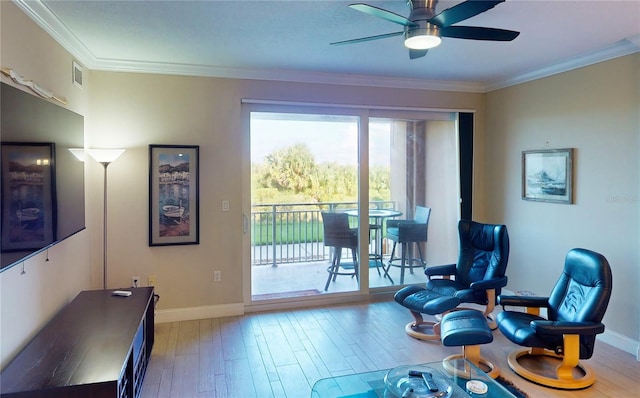 sitting room featuring wood-type flooring, ornamental molding, and ceiling fan