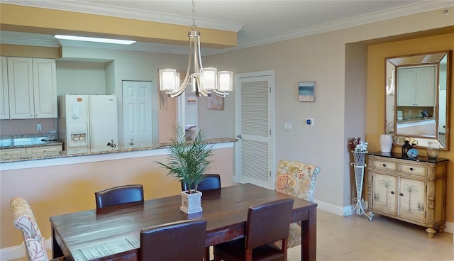 dining room with light hardwood / wood-style floors, ornamental molding, and a notable chandelier