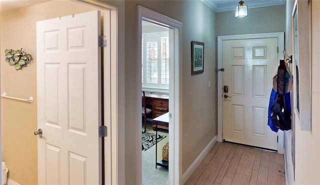 foyer entrance featuring ornamental molding and light hardwood / wood-style flooring