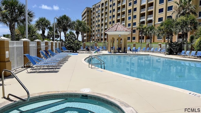 view of swimming pool featuring a hot tub and a patio area