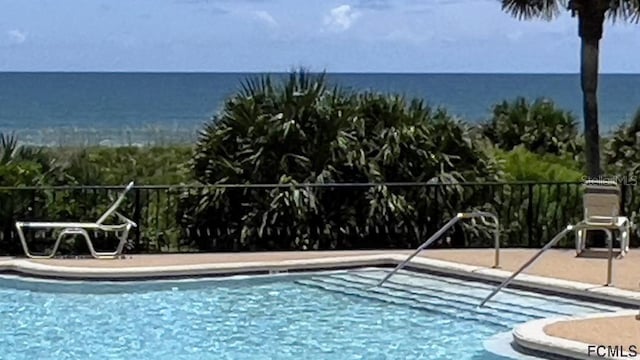 view of swimming pool with a water view