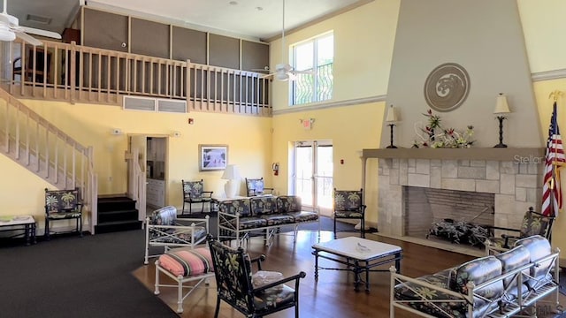 living room with a high ceiling, dark hardwood / wood-style floors, and ceiling fan