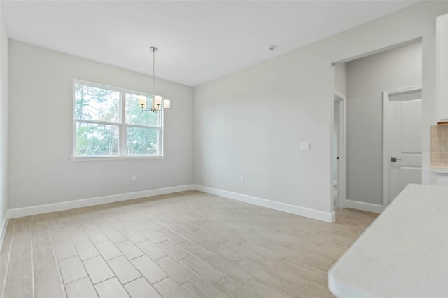 unfurnished dining area featuring a chandelier and light hardwood / wood-style flooring