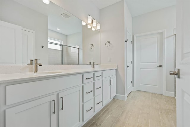 bathroom featuring vanity, hardwood / wood-style floors, and a shower with door