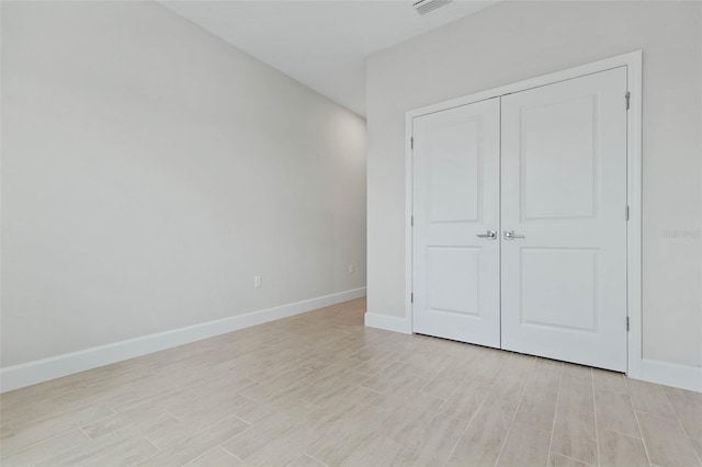 unfurnished bedroom with light wood-type flooring and a closet