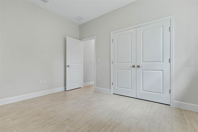 unfurnished bedroom with a closet and light hardwood / wood-style floors