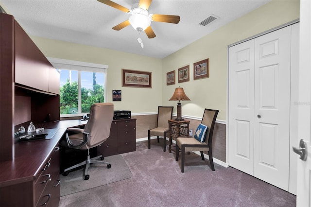 office featuring a textured ceiling, carpet flooring, and ceiling fan