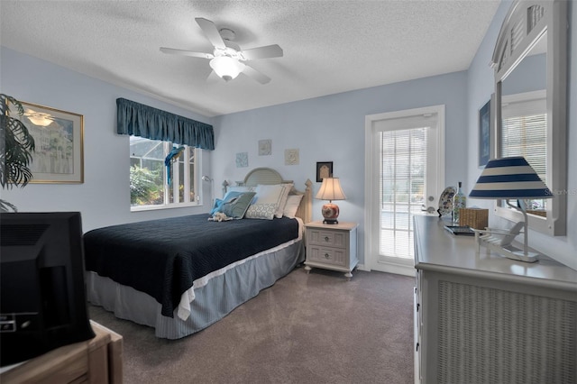 bedroom featuring dark colored carpet, a textured ceiling, and ceiling fan