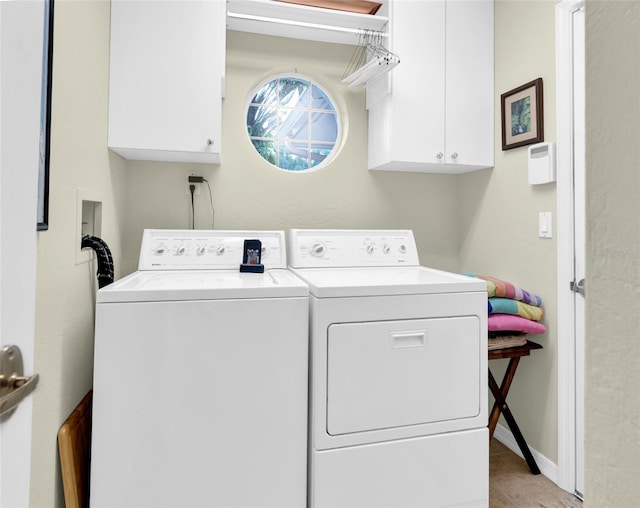 laundry area featuring light tile patterned floors, cabinets, and washer and clothes dryer