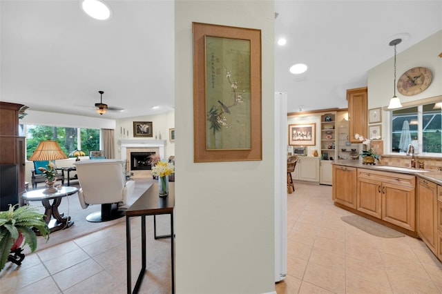 kitchen with light tile patterned flooring, decorative light fixtures, sink, and ceiling fan