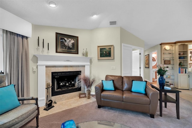 living room featuring vaulted ceiling, a fireplace, and light colored carpet