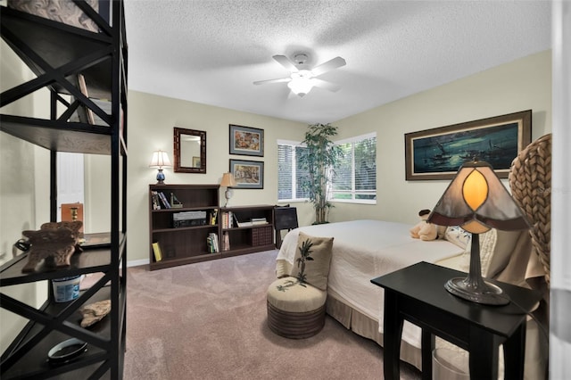 bedroom with a textured ceiling, carpet flooring, and ceiling fan