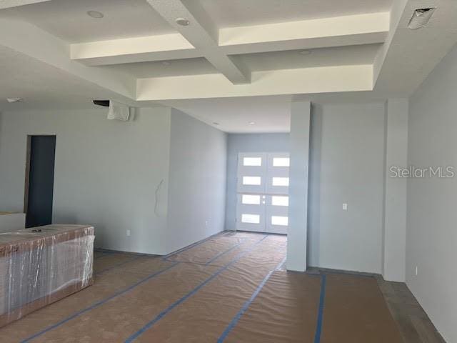 unfurnished living room with coffered ceiling and beam ceiling