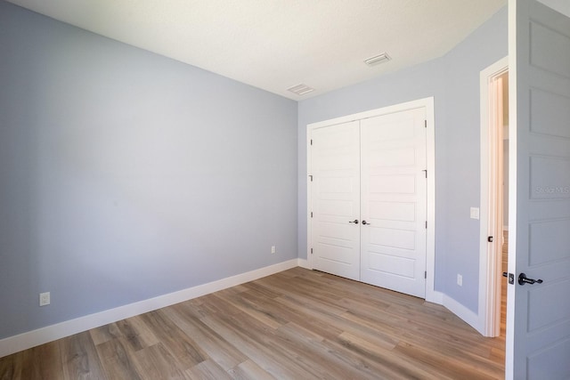 72 Flemingwood Ln, Palm Coast, FL 32137 - unfurnished bedroom with light wood-style flooring, baseboards, and a closet