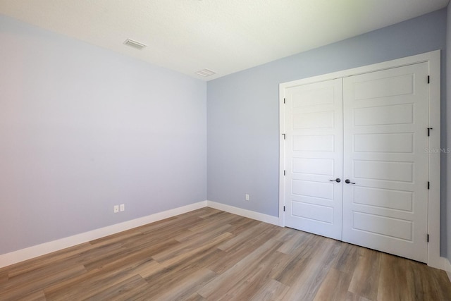 72 Flemingwood Ln, Palm Coast, FL 32137 - unfurnished bedroom featuring wood finished floors, a closet, and baseboards