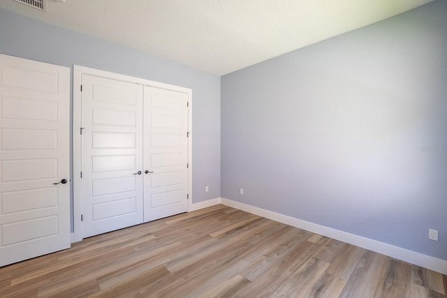 72 Flemingwood Ln, Palm Coast, FL 32137 - unfurnished bedroom with light wood-style flooring, a closet, and baseboards