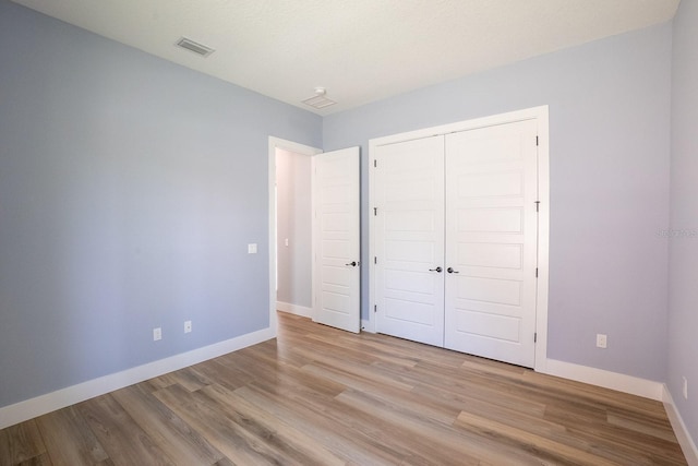 72 Flemingwood Ln, Palm Coast, FL 32137 - unfurnished bedroom with baseboards, wood finished floors, and a closet