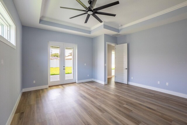72 Flemingwood Ln, Palm Coast, FL 32137 - spare room featuring crown molding, a raised ceiling, french doors, wood finished floors, and ceiling fan