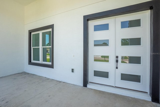 72 Flemingwood Ln, Palm Coast, FL 32137 - property entrance with stucco siding and a patio area