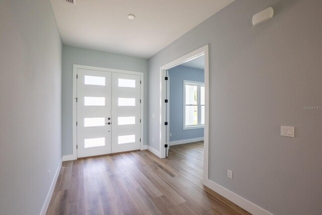72 Flemingwood Ln, Palm Coast, FL 32137 - entrance foyer with french doors, wood finished floors, and baseboards