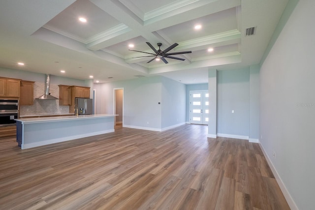 72 Flemingwood Ln, Palm Coast, FL 32137 - kitchen with wall chimney range hood, appliances with stainless steel finishes, brown cabinets, open floor plan, and light countertops