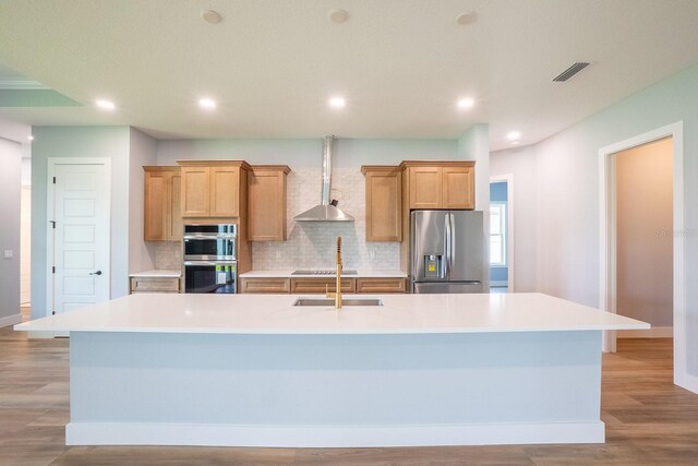 72 Flemingwood Ln, Palm Coast, FL 32137 - kitchen with appliances with stainless steel finishes, wall chimney exhaust hood, a spacious island, baseboards, and backsplash
