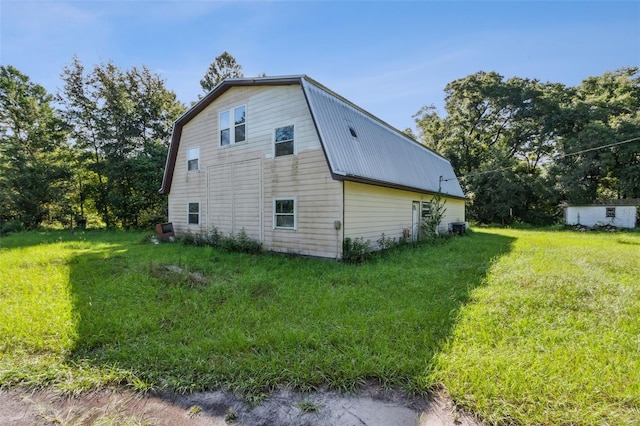 view of home's exterior with a lawn and central AC