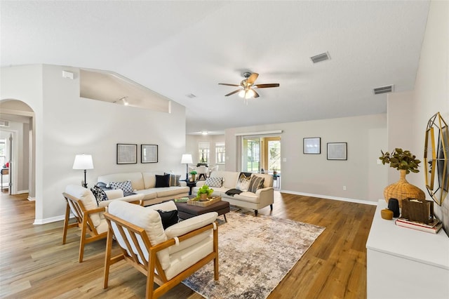 living room featuring ceiling fan, hardwood / wood-style floors, and vaulted ceiling