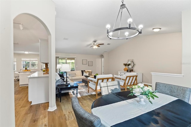 dining area featuring ceiling fan with notable chandelier and light wood-type flooring