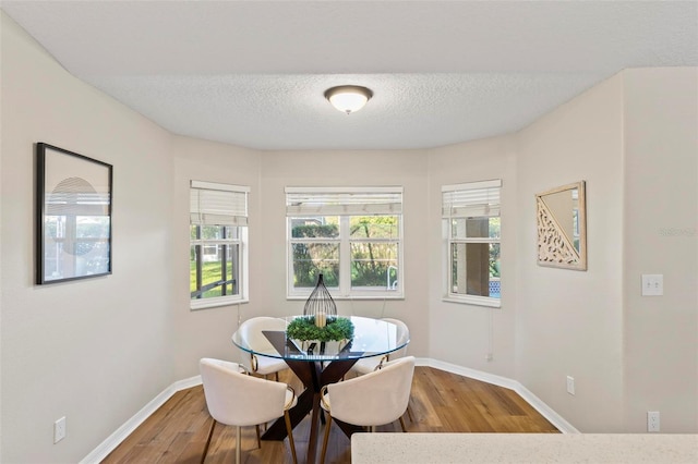 dining area featuring a textured ceiling and hardwood / wood-style flooring