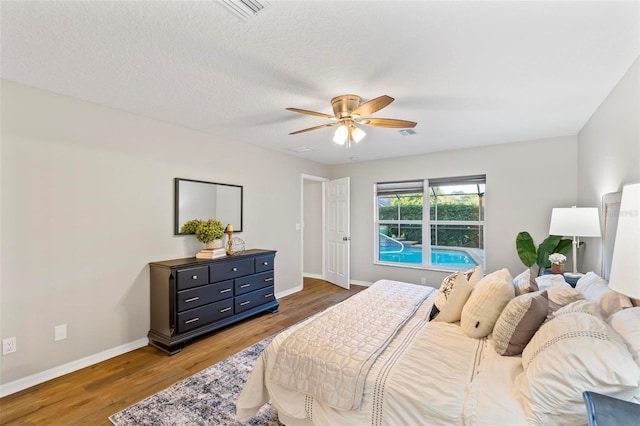 bedroom featuring ceiling fan, a textured ceiling, and dark wood-type flooring