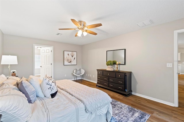 bedroom with connected bathroom, ceiling fan, and hardwood / wood-style floors