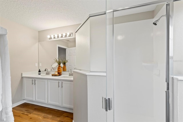 bathroom featuring a textured ceiling, vanity, hardwood / wood-style floors, and an enclosed shower