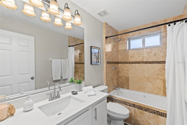 full bathroom featuring vanity, shower / bath combo with shower curtain, toilet, and a textured ceiling