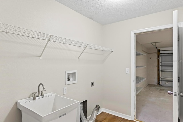 laundry room with hookup for an electric dryer, a textured ceiling, sink, and washer hookup