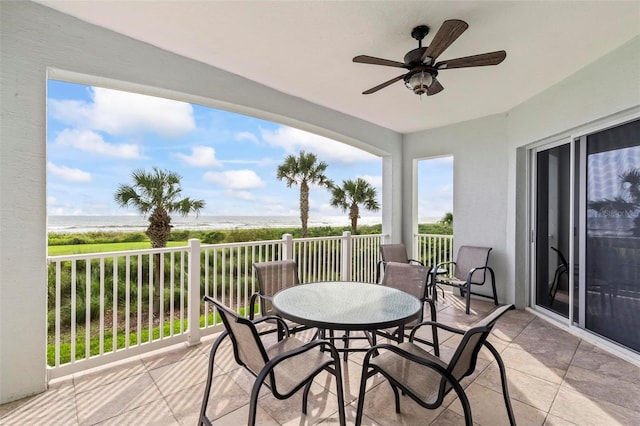 exterior space featuring ceiling fan, a water view, and a view of the beach