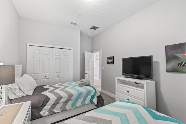 bedroom featuring carpet, a closet, and a textured ceiling