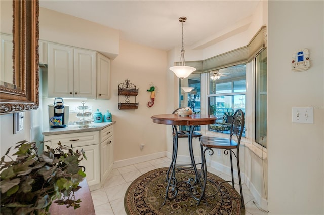 kitchen featuring white cabinets, ceiling fan, hanging light fixtures, and light tile patterned floors