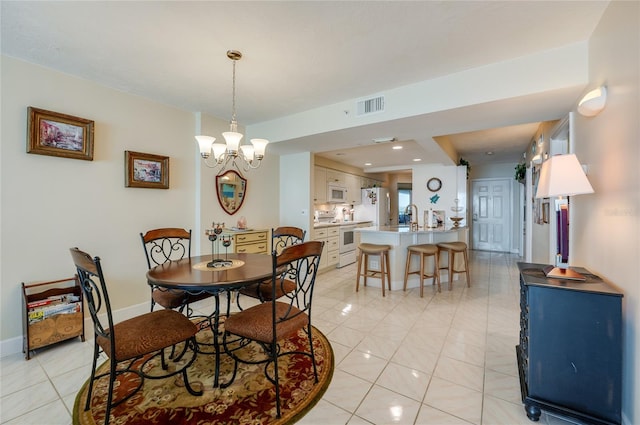 tiled dining space featuring sink and a notable chandelier