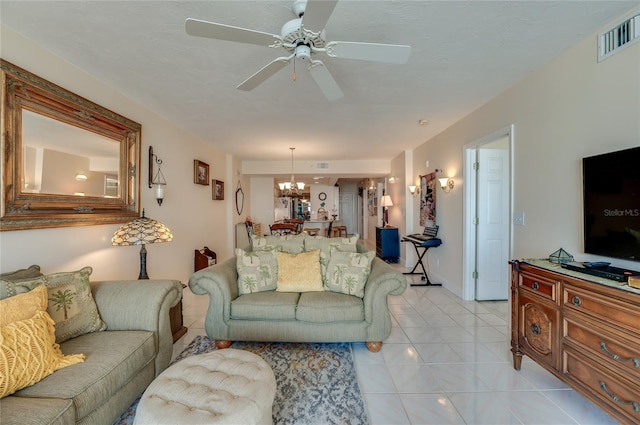 living room with ceiling fan with notable chandelier and light tile patterned flooring