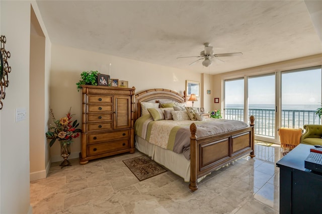 bedroom with a water view, ceiling fan, and access to outside