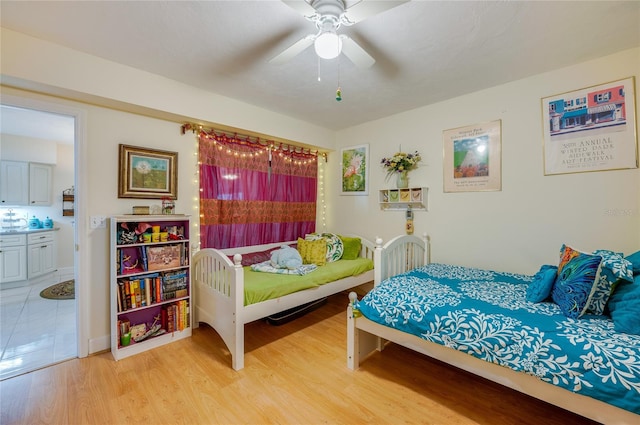 bedroom with ceiling fan, light hardwood / wood-style flooring, and ensuite bathroom