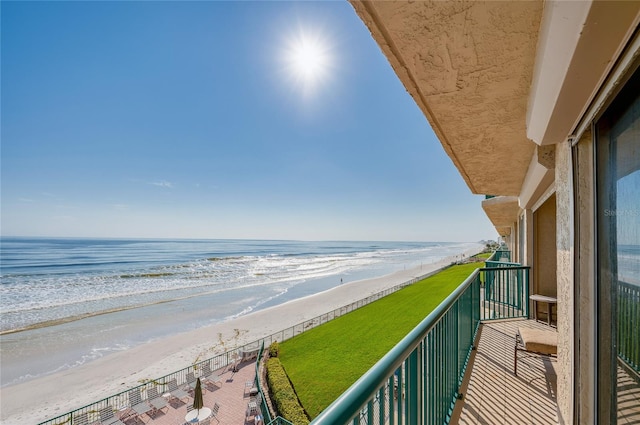 balcony featuring a beach view and a water view