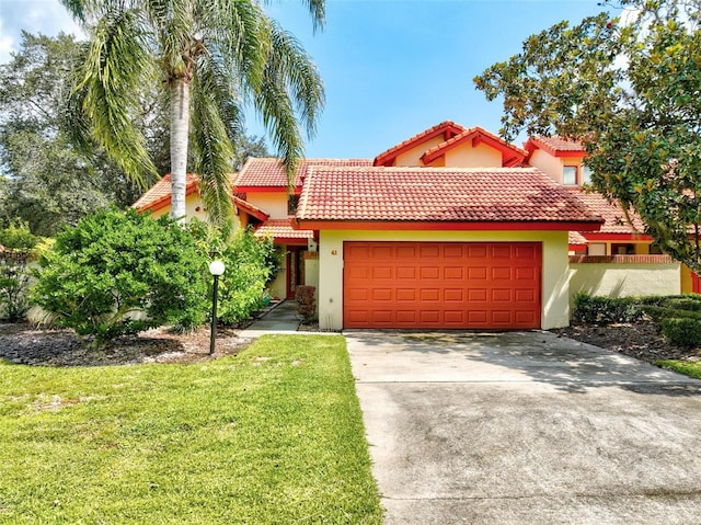 mediterranean / spanish-style home with a garage and a front lawn