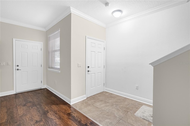 foyer featuring a textured ceiling, ornamental molding, and hardwood / wood-style floors