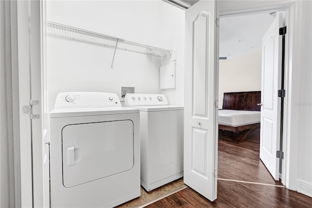 laundry room with independent washer and dryer and dark wood-type flooring